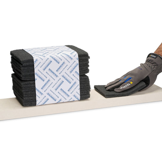 STARCKE Schleifvlies Pads Siliciumcarbid 152x229 mm, Anwendungsbeispiel mit Arbeitshandschuh auf Oberfläche.