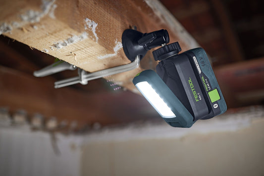 Festool Magnetkugelkopf MA KAL mit LED-Leuchte an Holzbalken montiert, 360° drehbar für flexible Arbeitspositionierung.
