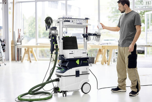Festool CLEANTEC CTM 36 EI AC Absaugmobil in Werkstatt, Handwerker bedient Staubabsauganlage mit Saugschlauch und