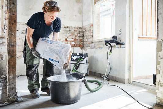 Festool Rührwerk MX 1200 RE EF HS2 mit ErgoFix-Höhenverstellung beim Mischen in Eimer, Absauganlage im Hintergrund