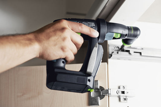 Festool Winkelvorsatz XS-AS in Hand bei Anwendung in Engstelle an Steckdose montiert