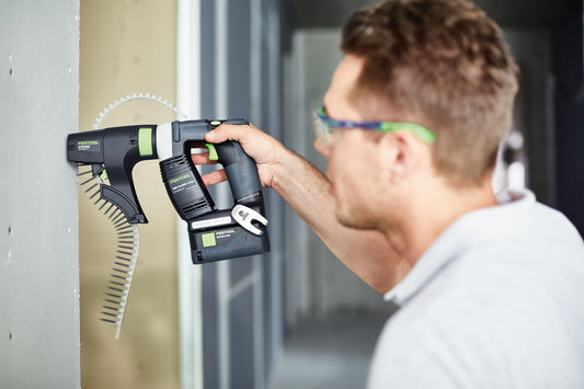 Festool DURADRIVE DWC 18-2500 Akku-Bauschrauber bei Anwendung im Trockenbau an Rigipsplatte, Magazinvorsatz mit Schrauben