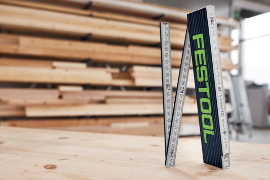 Festool Meterstab Holzgliedermaßstab mit 10 Gliedern, dunkelblau-grünes Design, aufgeklappt auf Holzoberfläche