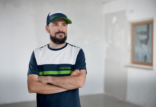 Festool Fashion Cap GC-FT2 in Dunkelblau, Grün und Weiß, getragen von Mann mit verschränkten Armen