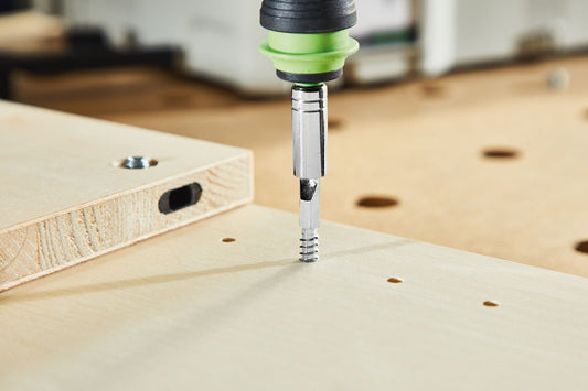 Festool Eckverbinder Domino mit grünem Befestigungsclip beim Einschrauben in Holzplatte