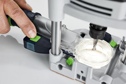 Festool LM-OF 1400 Absaughaube mit LED-Lichtmodul, grüner Schalter wird betätigt, Absaugansatz über Fräsbereich.