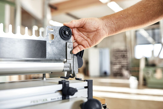 Festool Schwalbenschwanzzinken-Schablone wird in VS 600 Verbindungssystem eingelegt, Hand positioniert schwarzes Zahnrad