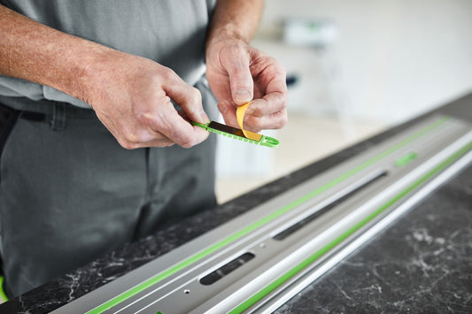 Festool Klebepad FS-KP/30 wird von Handwerker auf Führungsschiene angebracht zur Fixierung