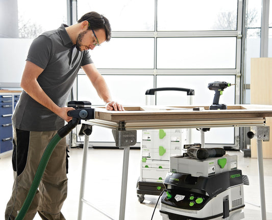 Festool Einhandhobel EHL 65 EQ-Plus in Anwendung beim Hobeln von Holz an Werkbank mit Absauganlage