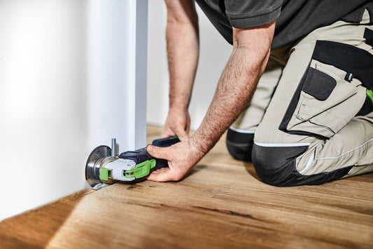 Festool Akku-Oszillierer VECTURO OSC 18 bei Eintauchschnitt an Holzboden, Handschuh sichtbar.