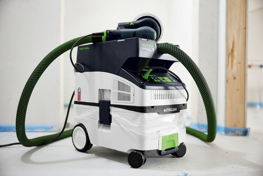 Festool CLEANTEC CTH MIDI I AC Absaugmobil mit grünem Schlauch und AUTOCLEAN Filterreinigung auf Baustelle