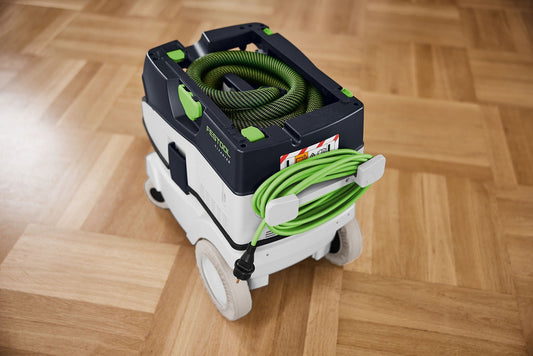 Festool Radüberzieher RD-CT 26-48 grün auf Sauger montiert mit aufgewickelter Schleifschlauchrolle auf Holzboden.
