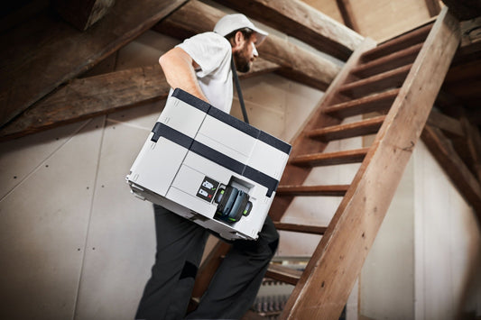 Festool CTLC SYS I-Basic Akku-Absaugmobil im Systainer-Format wird von Handwerker auf Baustelle transportiert