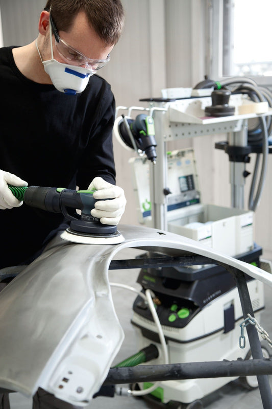 Festool LEX 3 150/3 Druckluft-Exzenterschleifer bei Anwendung auf weißem Werkstück mit Absauganlage