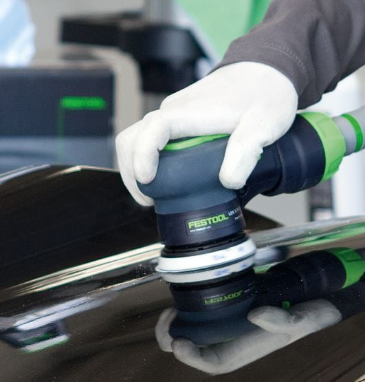 Festool Schleifscheibe Granat wird mit weißen Handschuhen auf Lackoberflächenschliff angewendet