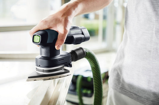 Festool Deltaschleifer DTS 400 in Anwendung beim Schleifen mit grünem Absaugschlauch