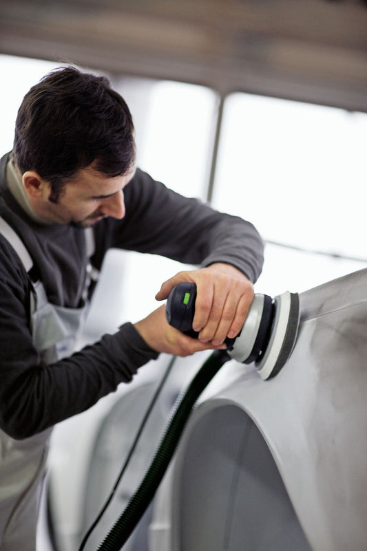 Festool Exzenterschleifer ETS 150/5 EQ in Anwendung beim Schleifen einer weißen Oberfläche