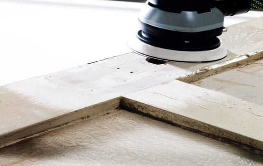 Festool ETS 150/5 EQ-Plus Exzenterschleifer bei Schleifarbeit auf Betonoberfläche mit Schleifteller