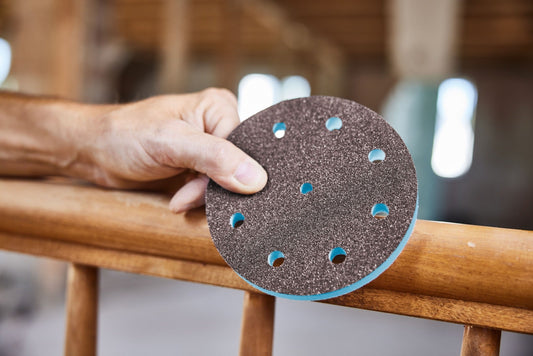 Festool Granat PROfile Schleifscheibe mit Lochbild wird von Hand auf Holzwerkstück gehalten