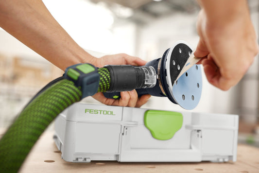 Festool Exzenterschleifer mit Granat D125 Schleifscheibe und grünem Systainer beim Schleifen von Holz