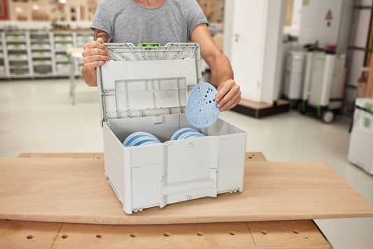 Festool Systainer³ SYS-STF D150 geöffnet mit blauem Schleifteller und sortierten Schleifmitteln in 8 Fächern.