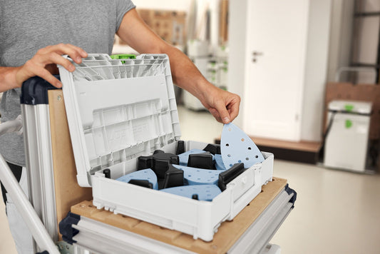 Festool Systainer³ M 112 mit sortiertem Schleifmittel Granat Delta in fünf Körnungen offen, Mann entnimmt Schleifblatt