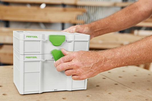 Festool Systainer³ SYS3 S 147 mit grünem T-LOC Verschluss, Hand öffnet Deckel auf Werkbank