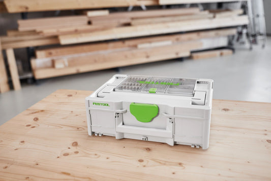 Festool Bitkassette BKS SYS3 25mm mit 24 Bits auf Holzwerkbank, grüner Griff, weiße Kunststoffbox.